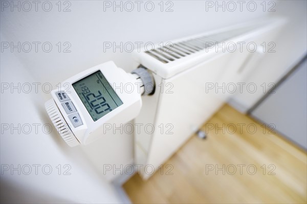 Symbolic photo on the subject of increased heating costs. Programmable radiator controller on a radiator. Berlin