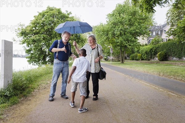 Temporary grandparents. Elderly couple volunteer to look after a boy from Africa for a few hours a week.