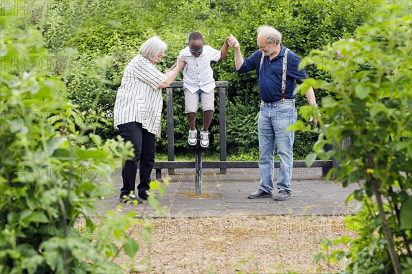 Grandparents on time. Grandparents with a boy on a playground.