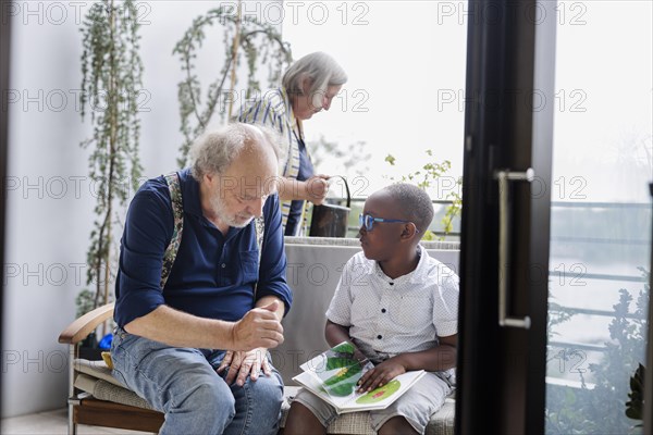 Temporary grandparents. Grandfather volunteers to look after a boy from Africa for a few hours a week.