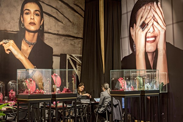 Showcases with high quality jewellery in front of photo wall with elegant woman