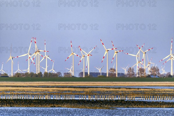 View of the wind farm behind the dike Friedrichskoog-Spitze in the evening