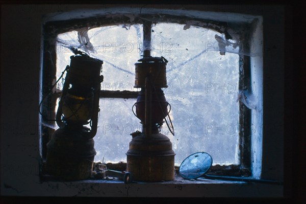 Two old stable lanterns in front of a cellar window