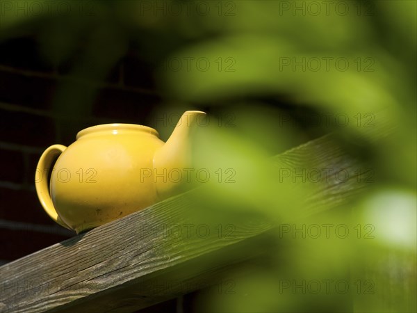 Old teapot on a wooden beam