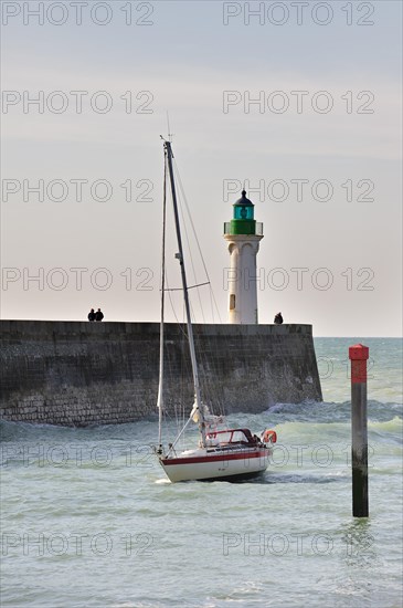 Lighthouse and sailing boat entering the harbour of Saint-Valery-en-Caux