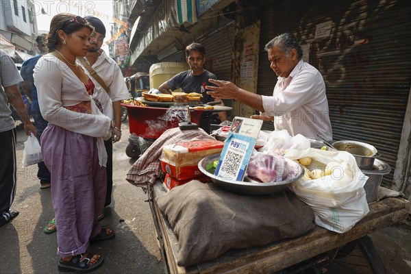 Street vendor with paytm logo for cashless payment at his stall in Paharganj