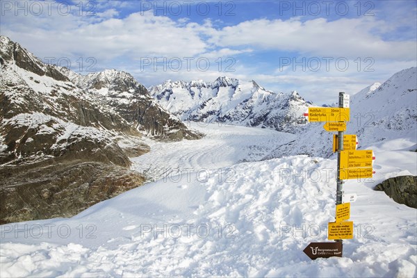 Signpost and view over the mountains in winter surrounding the Swiss Aletsch Glacier