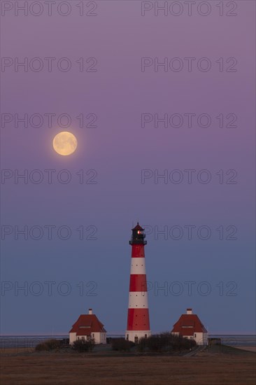 Lighthouse Westerheversand at sunset with full moon at Westerhever
