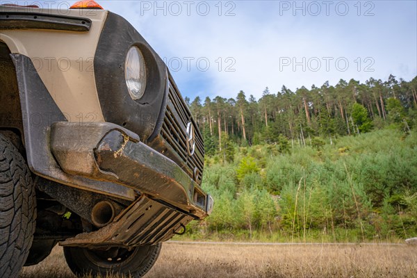 Front of a Mercedes off-road vehicle in front of the forest edge of the Enztalkiefer