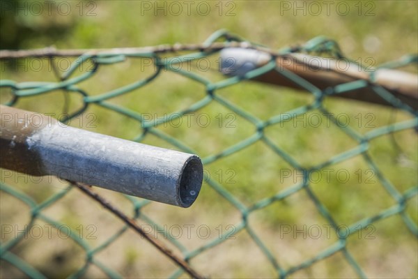 Broken railing on a chainlink fence