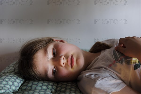 Child lying on the bed daydreaming