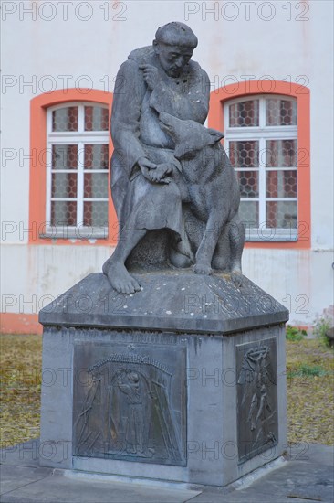 Monument with relief and sculpture of St. Francis with wolf figure at the former Jesuit monastery