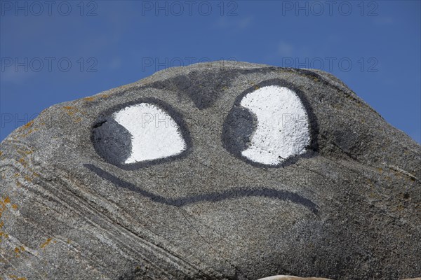 Eyes and mouth painted on rock