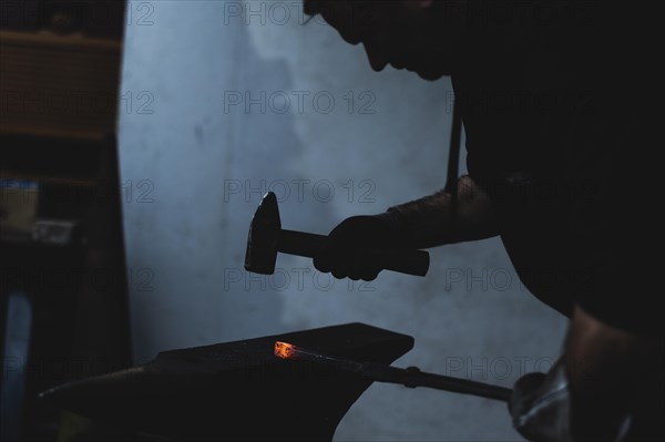 A metalworker works hot