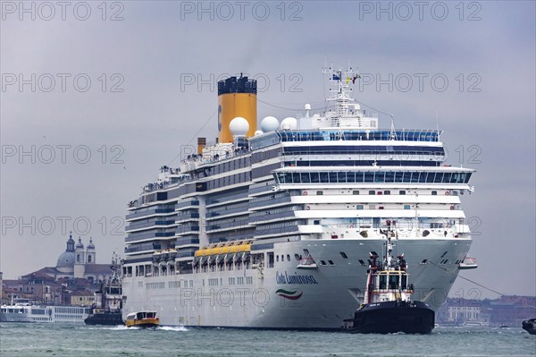 The cruise ship Costa Luminosa of the shipping company Costa Crociere sails to the cruise terminal Stazione Marittima. Meanwhile
