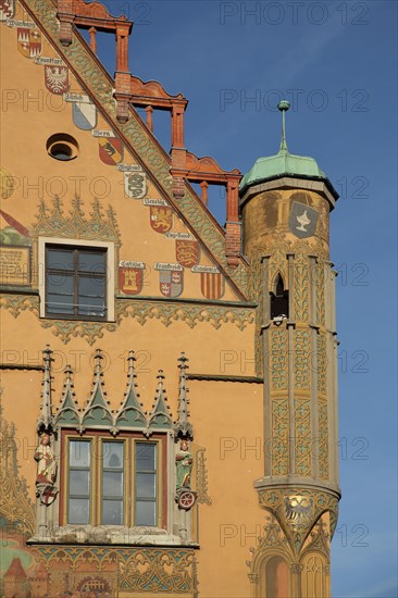 Ornate gable with bay window and mural of city arms on the town hall