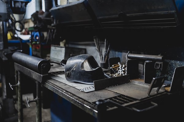 A welding helmet lying on a work plate