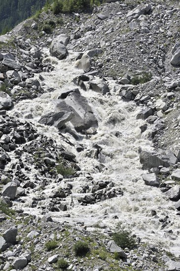 Mountain stream in the Alps with meltwater from a glacier