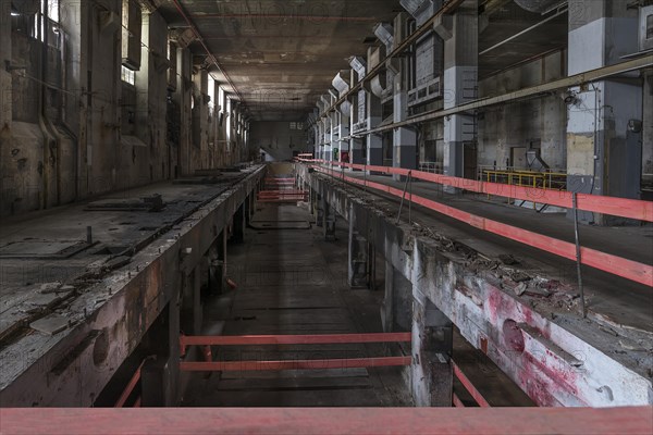 Security barrier in the empty production halls of a former paper factory