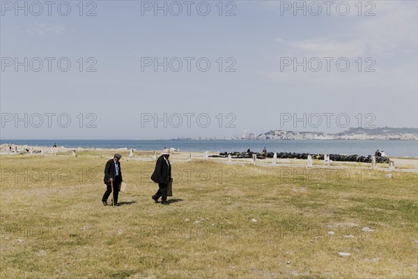 Two old men walking on the beach of Durres