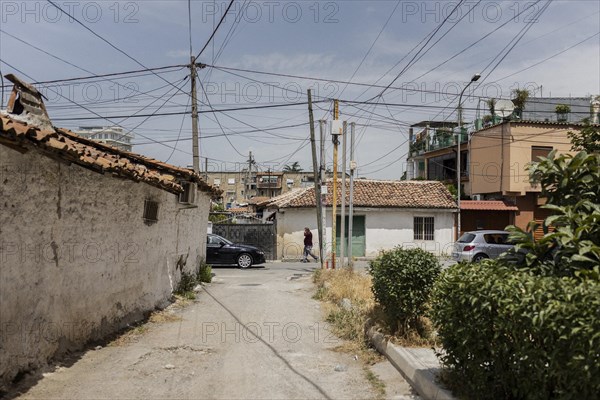 A person walking along a street in Tirana