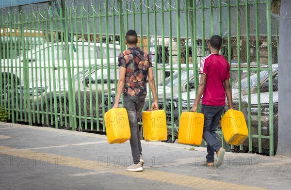 Men with water canisters. Street scene in Addis Ababa
