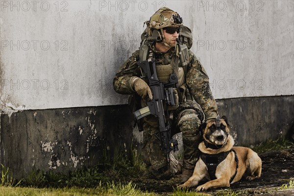 A soldier of the German Armed Forces with a mission dog