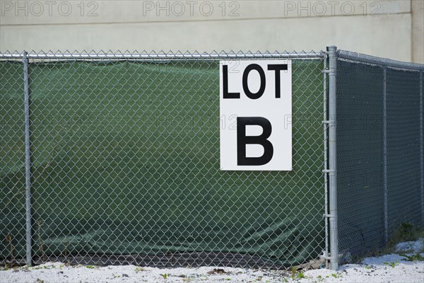 Sign on a chain-link fence reading