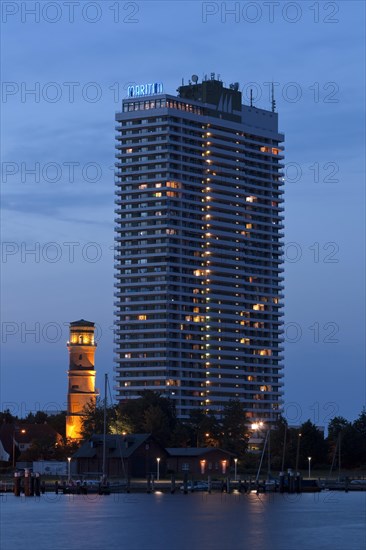 Maritim Hotel and the old lighthouse in the port of Travemuende at dusk