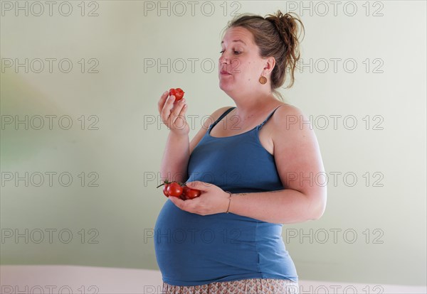 Pregnant woman eating tomatoes