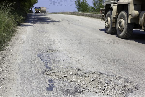 Bumpy road with pothole