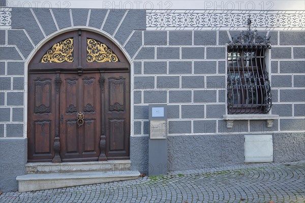 Portal and wooden door with ornamentation and lattice on the window at the Leube house in the Fischerviertel