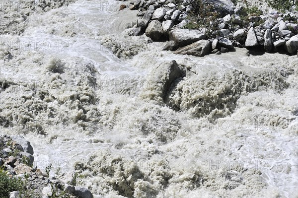 Mountain stream in the Alps with meltwater from a glacier