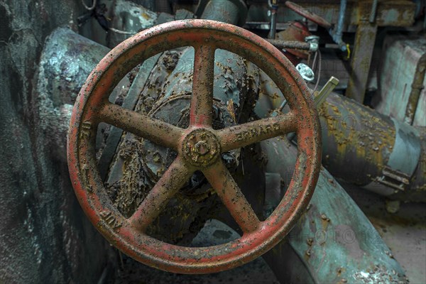 Rusty shut-off wheel on a water pipe of a former paper factory