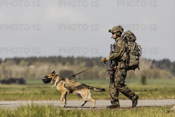 A soldier of the German Armed Forces with a mission dog