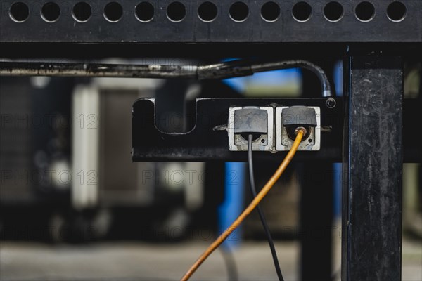 Two plugs stuck in sockets under a worktop