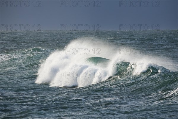 Big wave breaks in the open sea on the Breton coast near Brest