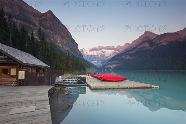 Red canoes at glacial Lake Louise with Victoria glacier