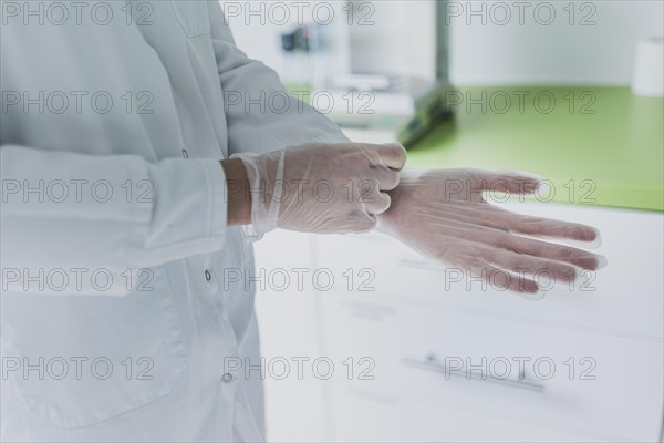 An employee uses disposable gloves in the prescription