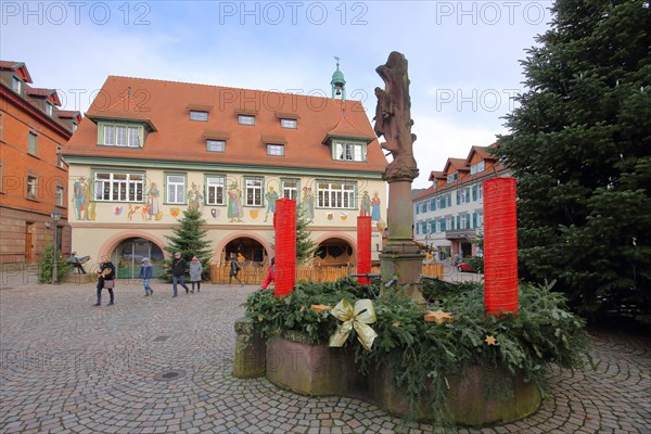 Historic town hall with wall painting and Christmas decoration with Advent wreath and Christmas tree