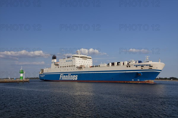 Ro-ro passenger ferry Finnpartner from Finnlines passing lighthouse Travemuende Nordmole