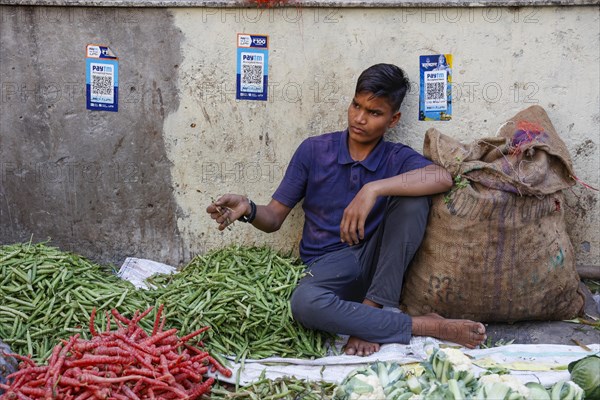 Vegetable street vendor with paytm logo for cashless payment on the wall in Paharganj