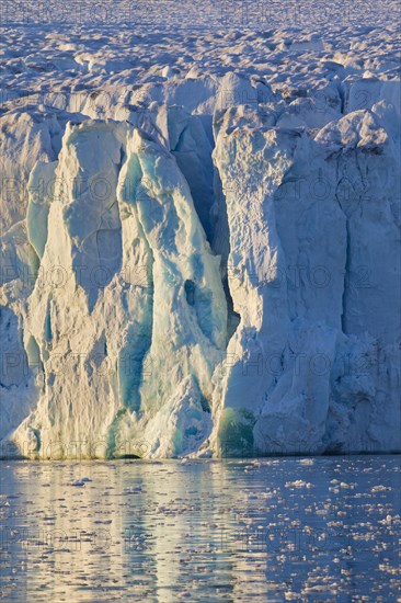 Cracked ice sheet of glacier calving into Arctic sea