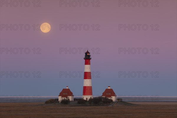 Lighthouse Westerheversand at sunset with full moon at Westerhever