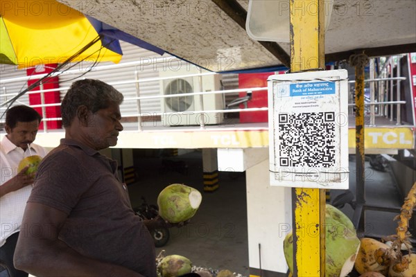 QR code for cashless payment at the stall of a coconut vendor in Trichy