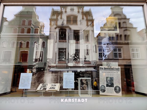 View into the shop window with reflections of gabled houses