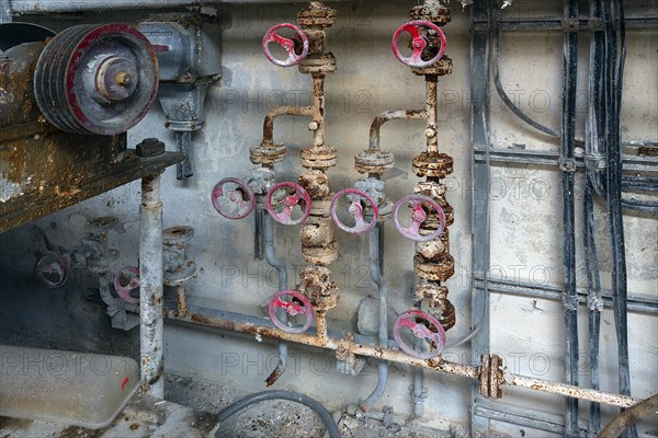 Rusty taps on water pipes of a former paper factory