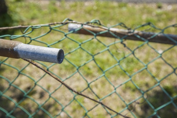 Broken railing on a chainlink fence