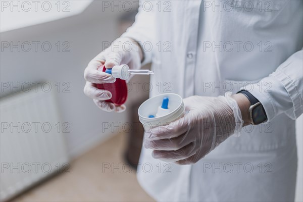 A prescription worker uses a dropper pipette