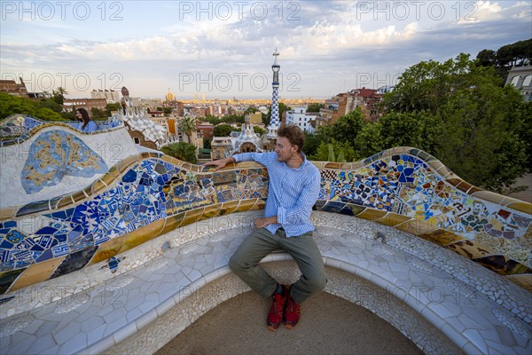 Young man on bench with colourful mosaic